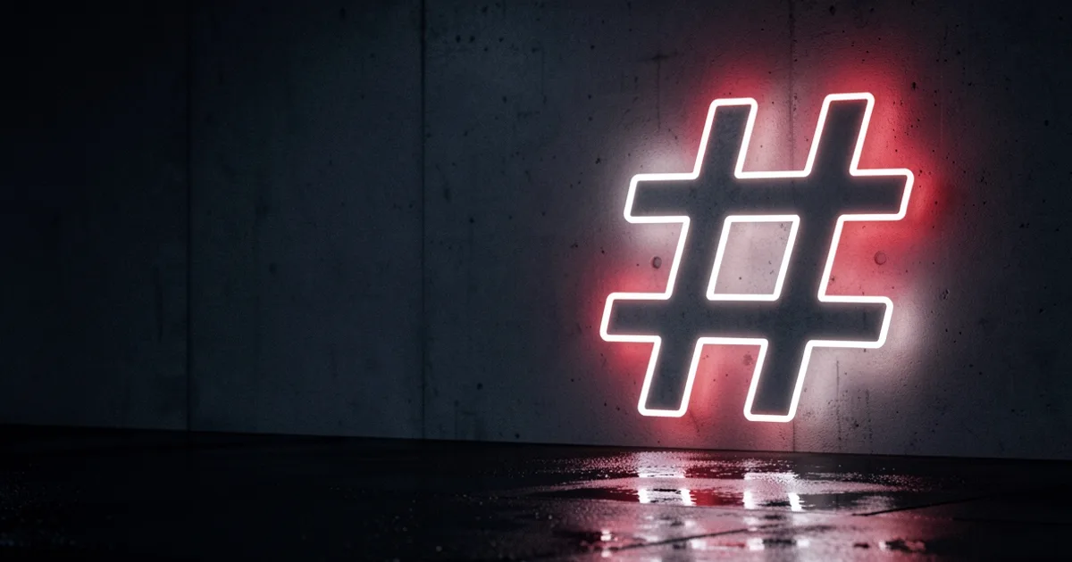 A glowing white neon hashtag symbol on a dark concrete wall with a red backlight